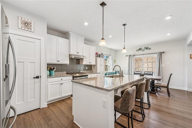 334 Crossing Dr, North Strabane, PA 15330 - kitchen featuring under cabinet range hood, dark wood finished floors, stainless steel gas range oven, decorative backsplash, and an island with sink