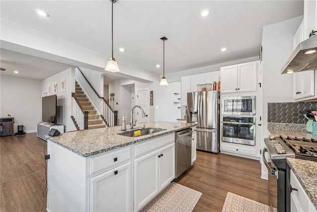 kitchen featuring appliances with stainless steel finishes, white cabinets, a sink, and extractor fan