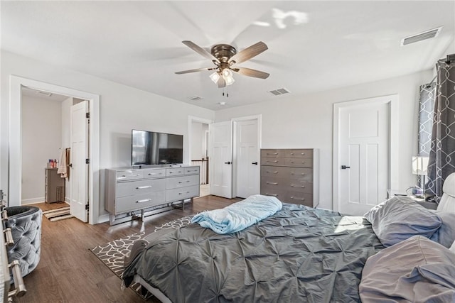 bedroom featuring dark wood-style floors, baseboards, visible vents, and a ceiling fan