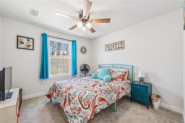 carpeted bedroom featuring a ceiling fan, visible vents, and baseboards