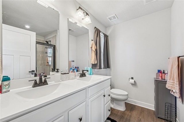 bathroom with double vanity, a stall shower, visible vents, and a sink