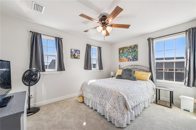 bedroom featuring baseboards, visible vents, ceiling fan, and light colored carpet