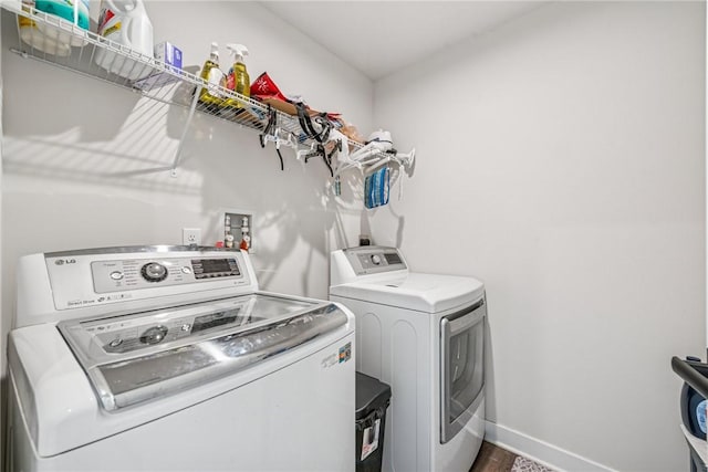 washroom with laundry area, independent washer and dryer, and baseboards