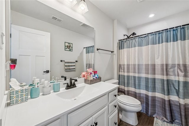 full bathroom featuring visible vents, vanity, toilet, and wood finished floors