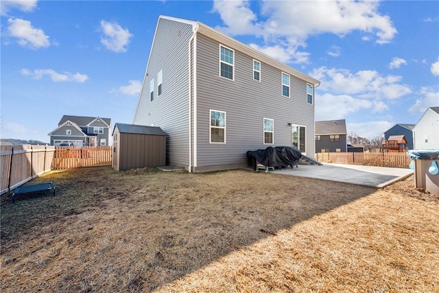 back of house with a patio area, an outdoor structure, a fenced backyard, and a shed