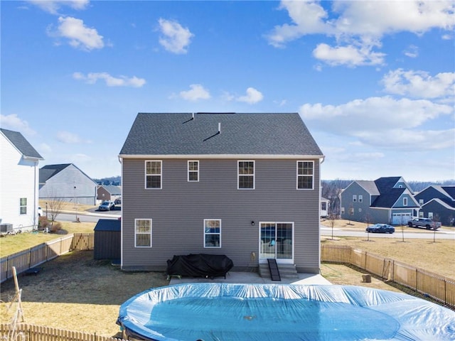 back of house featuring a shingled roof, a fenced in pool, a patio, a fenced backyard, and a residential view