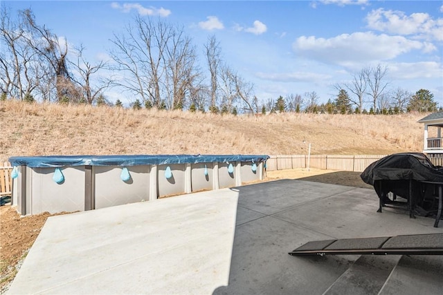 view of patio featuring a fenced in pool, a grill, and fence