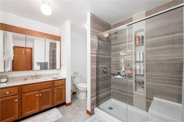 full bathroom featuring a shower stall, toilet, and vanity