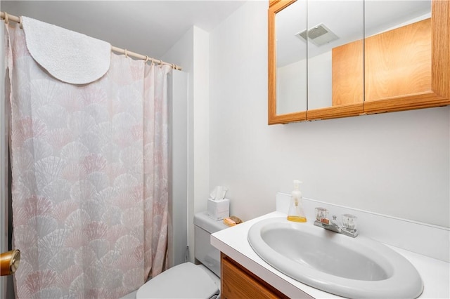 bathroom featuring toilet, vanity, visible vents, and a shower with curtain