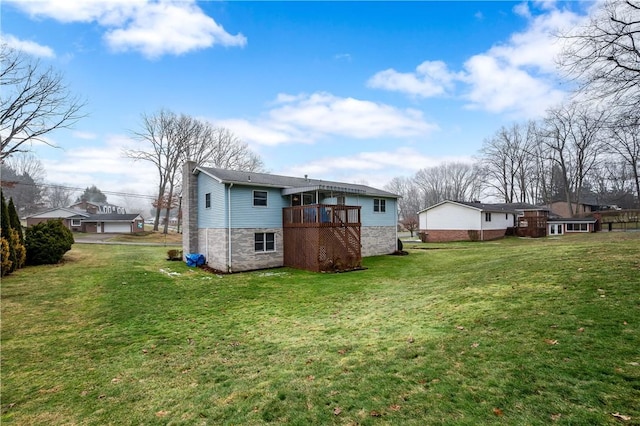 back of house featuring a chimney, a lawn, and a deck