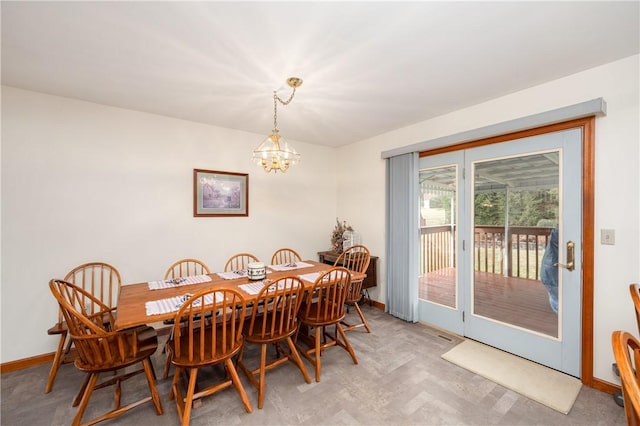 dining room with a chandelier, light carpet, and baseboards