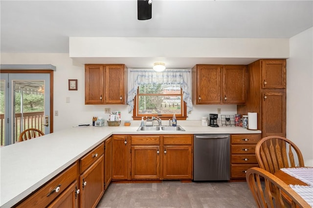 kitchen featuring light countertops, stainless steel dishwasher, brown cabinetry, and a sink