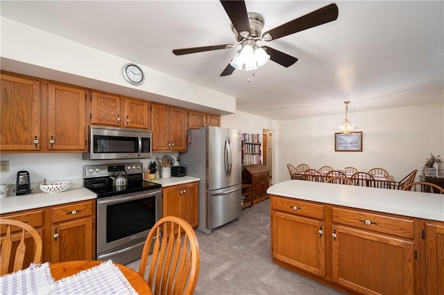 kitchen with light countertops, appliances with stainless steel finishes, and brown cabinetry