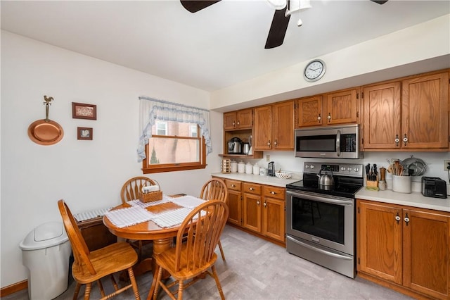 kitchen featuring appliances with stainless steel finishes, brown cabinets, and light countertops