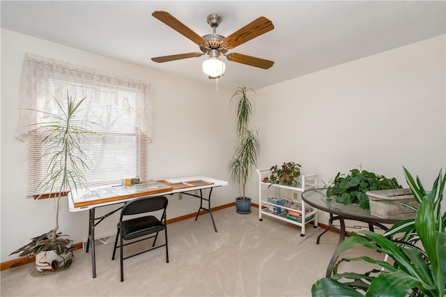 carpeted home office with a ceiling fan and baseboards