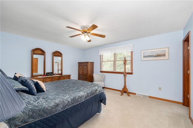 bedroom with light carpet, ceiling fan, visible vents, and baseboards