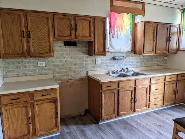 kitchen featuring light countertops, light wood finished floors, and brown cabinets