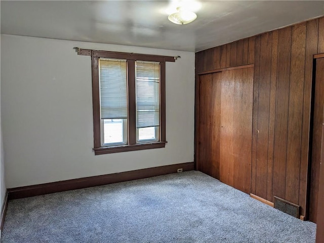 unfurnished bedroom featuring carpet floors, a closet, visible vents, and baseboards