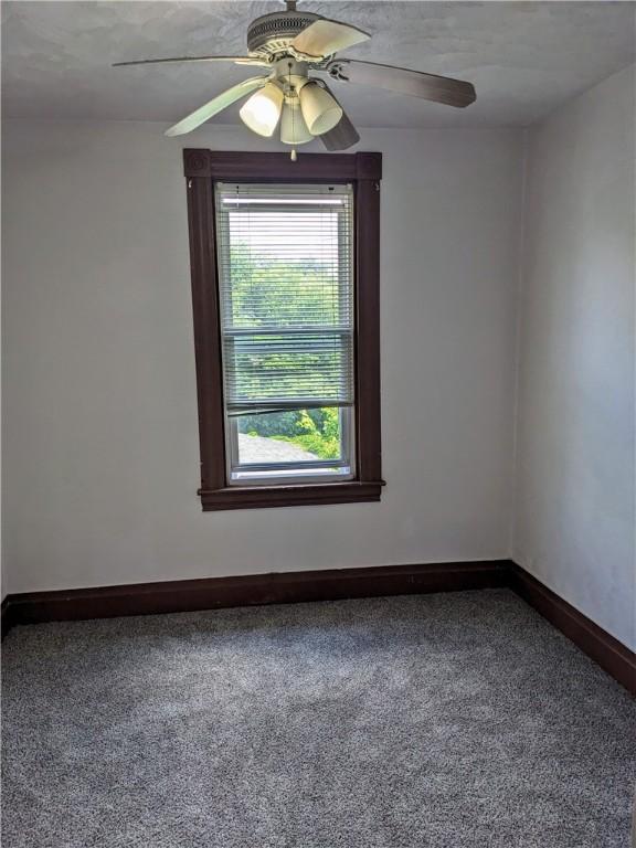 unfurnished room featuring ceiling fan, carpet floors, and baseboards