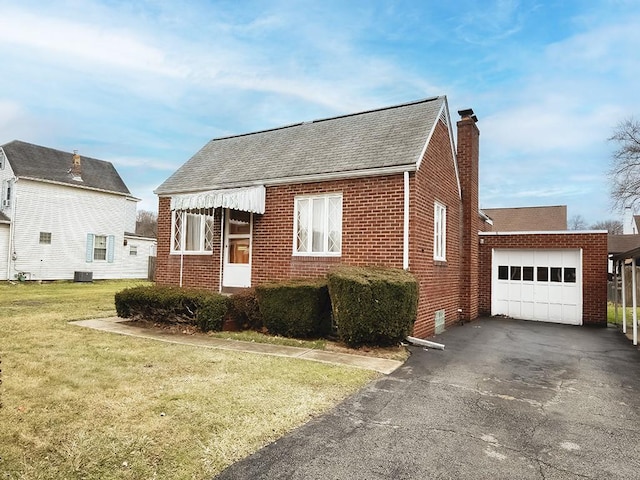 view of front facade featuring aphalt driveway, a garage, brick siding, a chimney, and a front yard