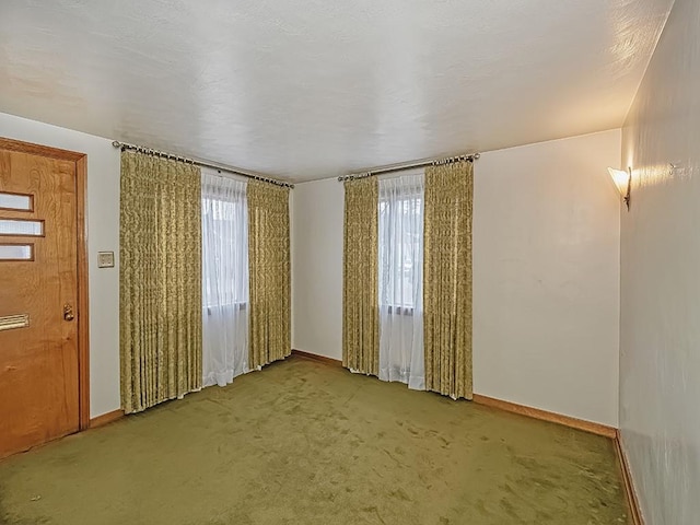 carpeted spare room with baseboards