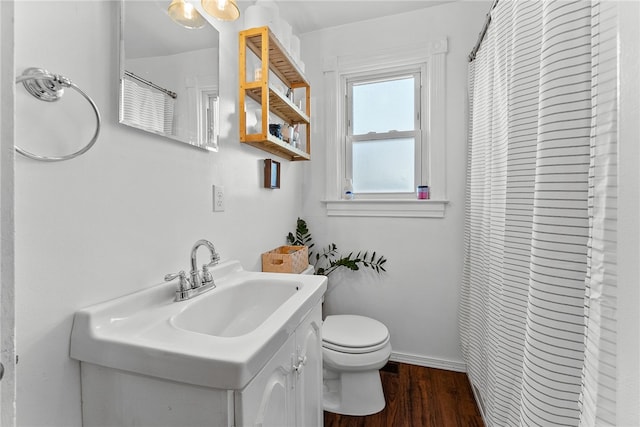 bathroom featuring toilet, vanity, wood finished floors, a shower with curtain, and baseboards