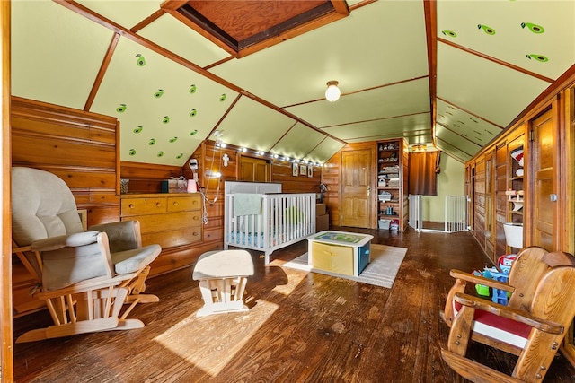 interior space with lofted ceiling, wood walls, and wood finished floors