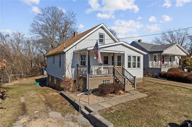 bungalow-style house with covered porch, a front lawn, and a chimney