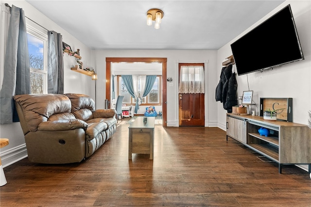 living room featuring dark wood-type flooring and baseboards