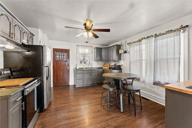 kitchen featuring stainless steel electric range oven, gray cabinets, dark wood-type flooring, a ceiling fan, and a sink