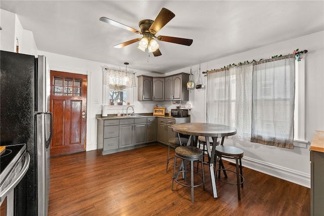 kitchen featuring dark wood finished floors, ceiling fan, appliances with stainless steel finishes, gray cabinetry, and a sink