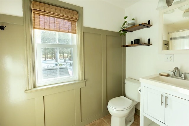 bathroom with tile patterned flooring, vanity, and toilet