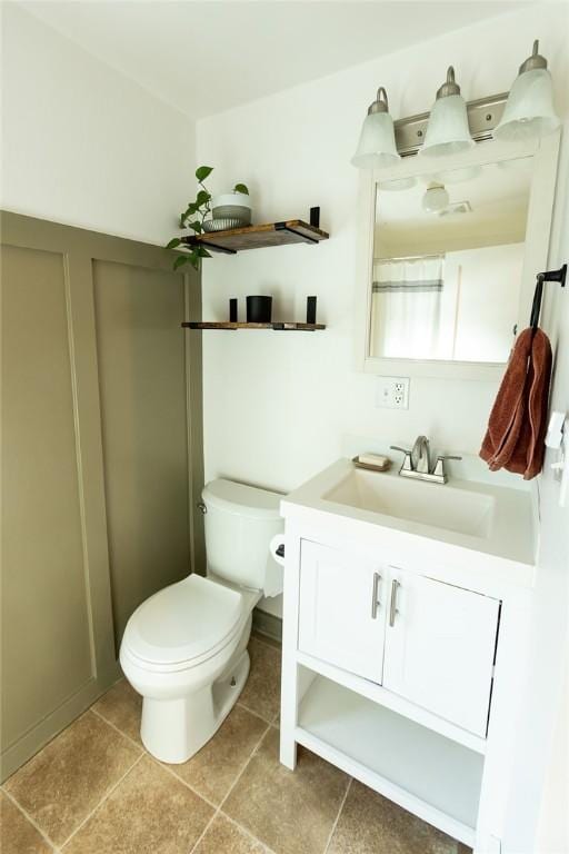 bathroom with toilet, tile patterned floors, and vanity