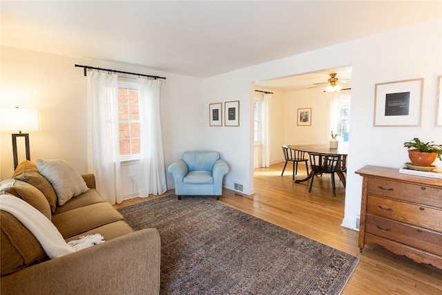 living area featuring visible vents, plenty of natural light, and light wood-style flooring