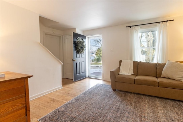 living area with a healthy amount of sunlight, baseboards, and wood finished floors