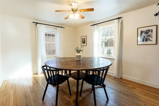 dining area featuring a healthy amount of sunlight, hardwood / wood-style flooring, ceiling fan, and baseboards