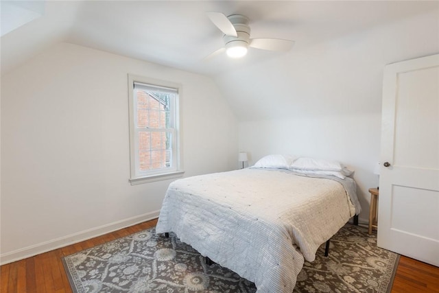 bedroom featuring ceiling fan, vaulted ceiling, baseboards, and wood finished floors