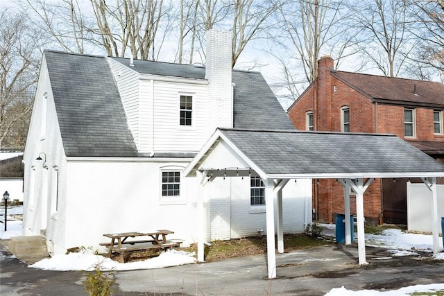 back of property with a chimney and brick siding