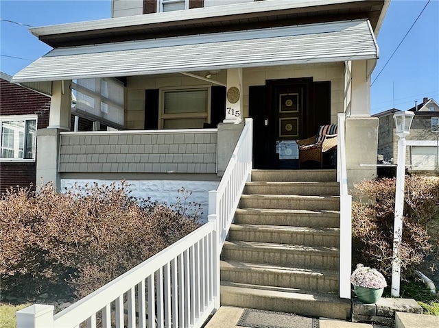 view of exterior entry featuring covered porch