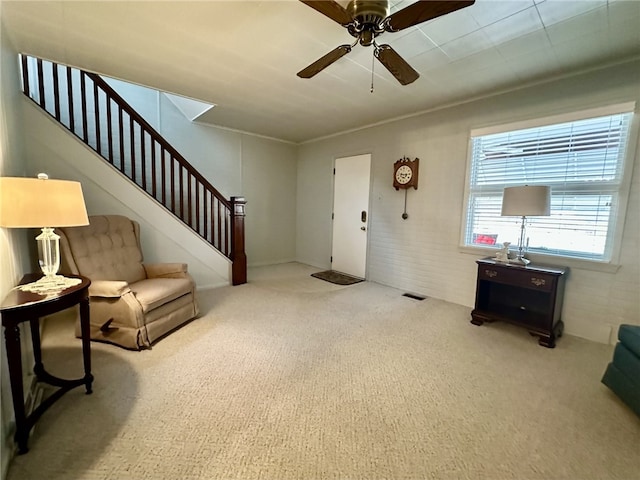 entryway featuring visible vents, a ceiling fan, ornamental molding, stairway, and carpet