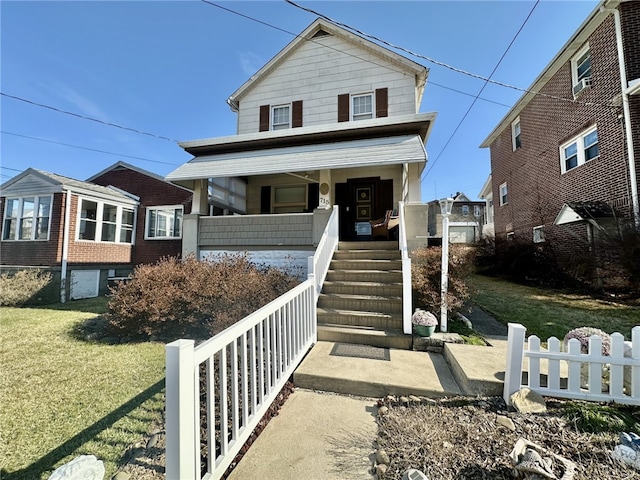 view of front of property featuring covered porch, stairway, fence, and a front lawn