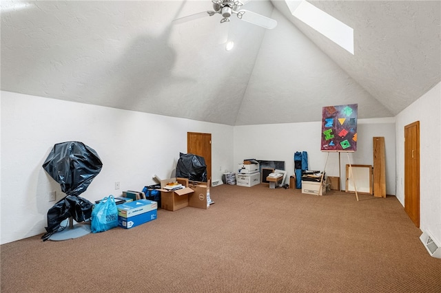 bonus room featuring a textured ceiling, vaulted ceiling with skylight, visible vents, a ceiling fan, and carpet