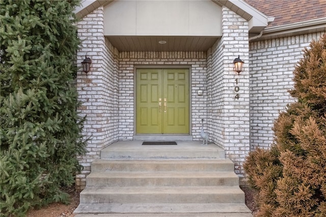 doorway to property with brick siding