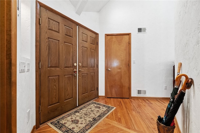 entryway with visible vents, light wood-style flooring, and baseboards