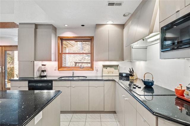 kitchen featuring recessed lighting, visible vents, a sink, dark stone counters, and black appliances