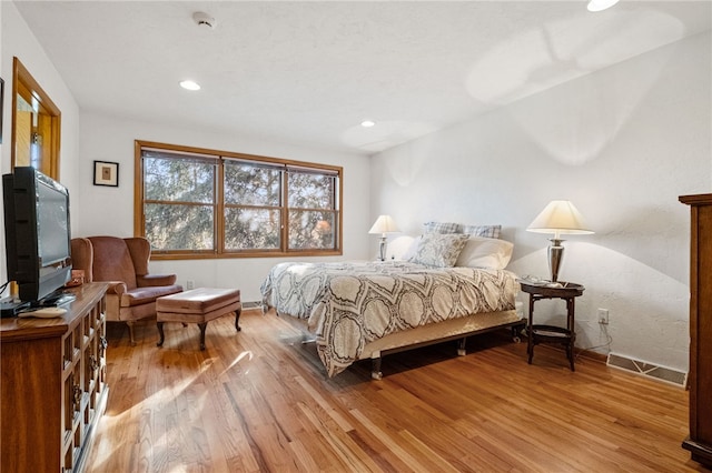 bedroom featuring baseboards, visible vents, wood finished floors, and recessed lighting