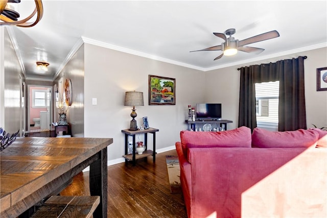 living room with dark wood-type flooring, crown molding, baseboards, and a ceiling fan