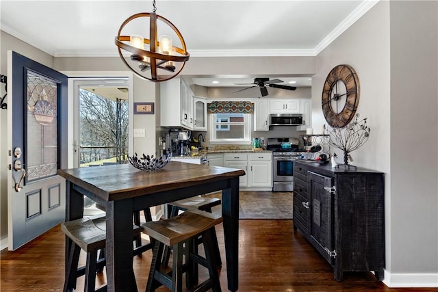 kitchen with stainless steel appliances, white cabinets, crown molding, and dark wood-style floors