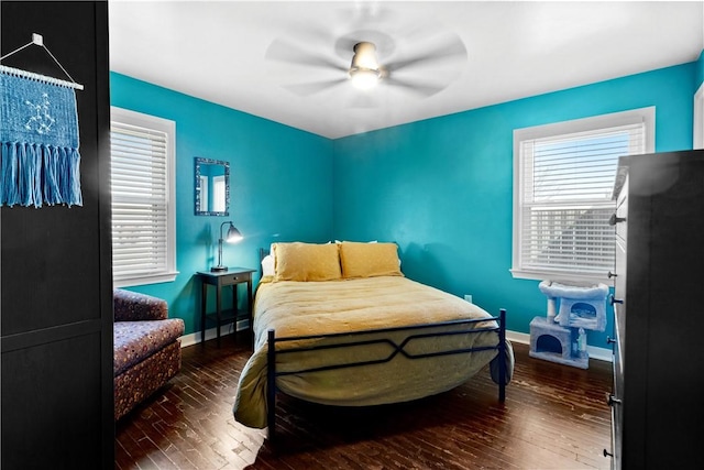 bedroom featuring multiple windows, ceiling fan, baseboards, and wood finished floors