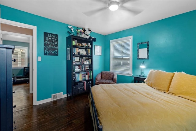 bedroom featuring baseboards, visible vents, ceiling fan, and wood finished floors